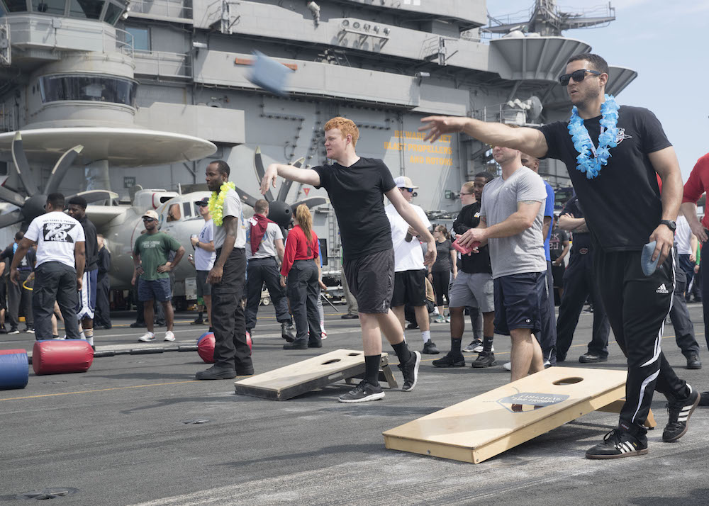 You really can play cornhole anywhere. These people are relaxing by playing cornole on the deck of the USS Harry Truman.