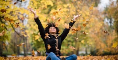 teenager-throwing-leaves-into-the-air