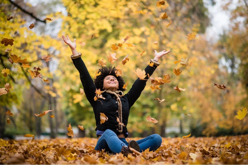 teenager-throwing-leaves-into-the-air