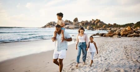 A family walking along the beach as a fun summertime activity.